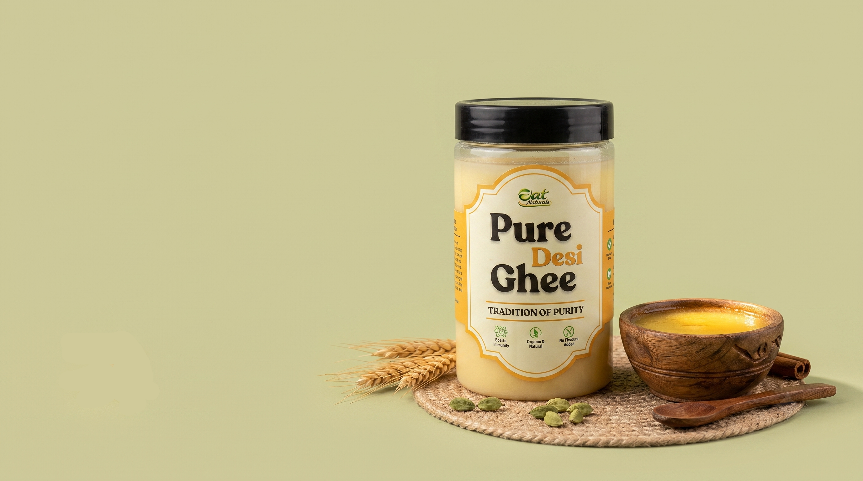 Pure Desi Ghee jar with wooden bowl, cardamom, and wheat stalks on jute mat, organic natural ghee